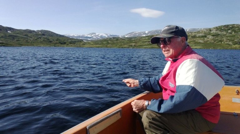 bilde av en eldre mann som fisker fra båt