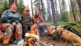 Tre fornøyde jegere i skogen og Alma som sitter og venter på neste drev. Bak kamera står Jaktleder Thorbjørn Erntzen.