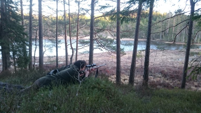 Mann som ligger med en rifle